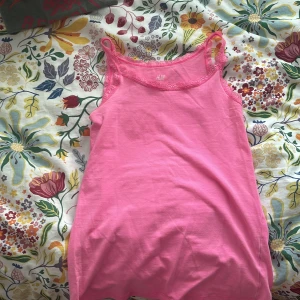 Rosa linnetopp med spets från H&M - Säljer en söt rosa linnetopp från H&M. Toppen har smala axelband och fina spetsdetaljer. Perfekt för varma dagar eller som lager under en tröja🩷