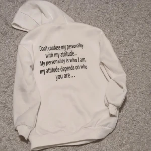 Vit hoodie med texttryck och huva - Säljer en vit hoodie med ett tryck på ryggen. Jag har bara använt den en gång och den är XS fast väldigt stor så hade säkert passat M också. Perfekt för dig som gillar statement-plagg och en clean look.