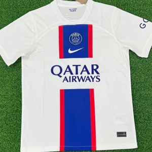 PSG vit matchtröja Nike - Vit PSG fotbollströja från Nike med blå och röda vertikala ränder på framsidan. Tröjan har klubbmärke och Nike-logga på bröstet samt Qatar Airways-tryck. Tillverkad i lätt och ventilerande material, perfekt för träning eller match. Hellt ny.