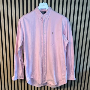 Ralph Lauren skjorta rosa - Rosa Ralph Lauren skjorta | Skick 8/10, en knapp har lossnat som man ser på bild 3 | 66cm bröstvidd, 62cm ärmlängd och 41cm kragmått, (Storlek L, rymlig passform) | Hör gärna av dig vid minsta fundering😊 