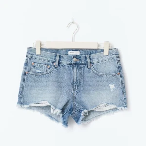 Blå jeansshorts  - Ljusblå jeansshorts från Gina tricot med låg midja, slitna detaljer och fransig kant. Använda fåtal gånger och har inga defekter. 