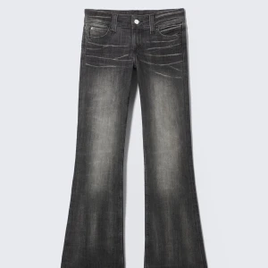 Svarta bootcut jeans  - Säljer ett par svarta bootcut från weekday . Jeansen har låg midja och klassisk femficksdesign. Materialet är jeans och passformen är normal med utsvängda ben. Perfekta för en trendig och avslappnad look.