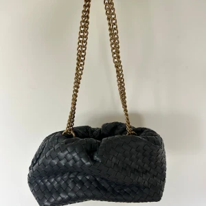 Svart flätad väska - Jättesnygg väska med guld kedjeband som går att använda både som en axelväska men även som en clutch🤍