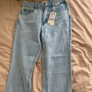 Ljusblå jeans med rak passform - Snygga ljusblå jeans med rak passform. De har en klassisk design med fem fickor och dragkedja. Perfekta för en avslappnad stil.