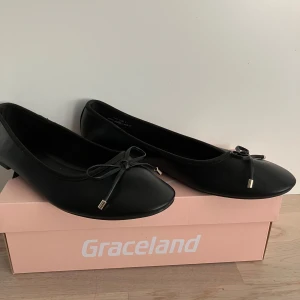 Svarta ballerinaskor från Graceland - Snygga svarta ballerinaskor från Graceland med en elegant rosett på tån. Perfekta för en stilren look och bekväma att bära hela dagen. Passar till många olika outfits. Oanvända!