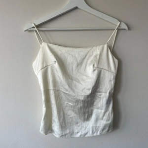Crémevit satin topp - Säljer en helt ny creme vit satin topp som endast är testad 🤍 den är öppen i ryggen! 