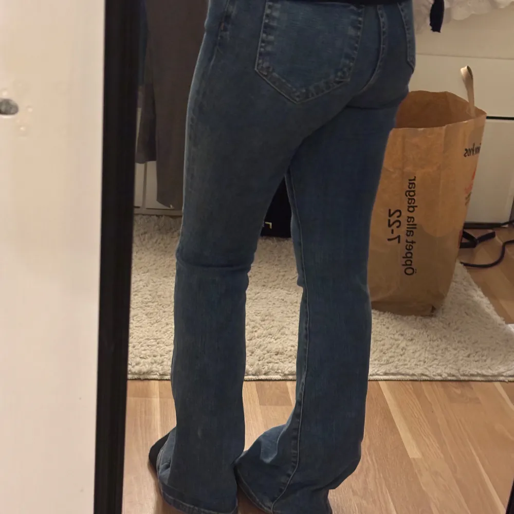 Snygga blå bootcut jeans med hög midja. Perfekta för en avslappnad stil med en klassisk touch. De har en smickrande passform och är tillverkade i ett bekvämt denimtyg.. Farkut & Housut.