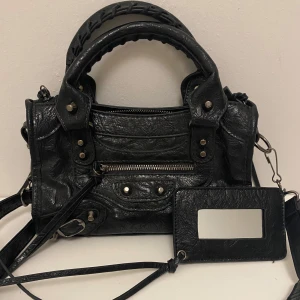 Liten svart handväska  -  Svart handväska i skinn med justerbart axelremsband som medföljer💗skriv vid frågor och måtten på väskan är 24x8x15 cm💗