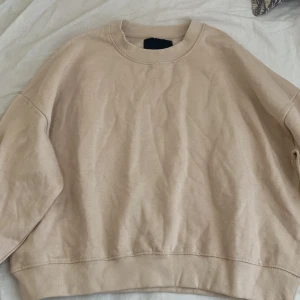 Beige sweatshirt - Säljer en stilren beige sweatshirt med rund hals och långa ärmar. Perfekt för en avslappnad look. Passar bra till jeans eller leggings.