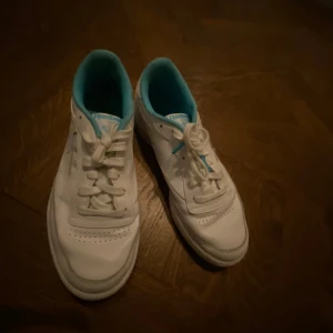Vita sneakers från Reebok - Snygga vita sneakers och tennisskor från Reebok med turkos insida och klassisk snörning. Perfekta för en avslappnad stil och bekväma att bära hela dagen.