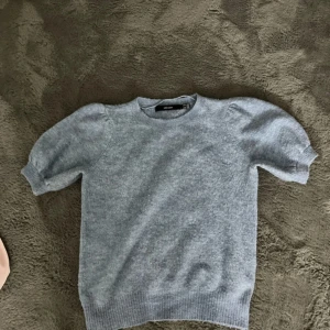Ljusblå stickad tröja från Vero Moda - Säljer en ljusblå stickad tröja från Vero Moda. Tröjan har korta puffärmar och en rund halsringning. Perfekt för en stilren och bekväm look. Är i storlek M men passar för folk med XS/S också. Hör av dig vid intresse! 💙