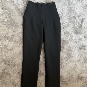 Kostymbyxor från Zara - Snygga svarta byxor från Zara med hög midja och en elegant, rak passform. Perfekta för en stilren look. 