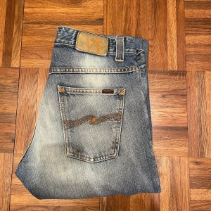 Blå Nudie Jeans 30/32 - Sköna nudie jeans. 30/32 i mått. Blåa med ljus wash på framsidan. Raka med lite bootcut. Lite fläckar på knäna, men inget som sticker ut.