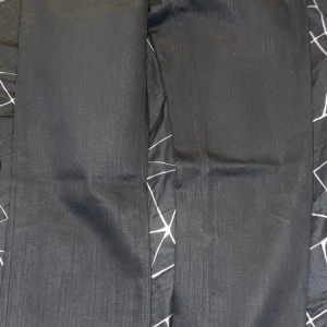 Svarta jeans från Prada - Snygga svarta jeans från Prada med klassisk design. De har en dragkedja och knappar framtill samt en diskret logga på bakfickan. Perfekta för en stilren look. /27 