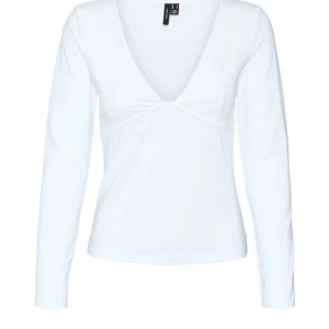 Vit långärmad topp från Vera Moda  - Säljer en stilren vit långärmad topp från Vera Moda med en djup v-ringning. Perfekt för en enkel och elegant look. Passar bra till både jeans och kjol.