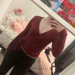 omlottopp - Säljer en snygg vinröd omlottopp från 157. Toppen har långa ärmar och ett knytband i midjan för en smickrande passform. Aldrig kommit till användning 