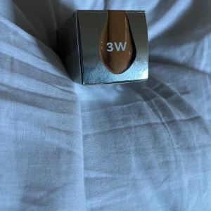 Foundation från CAIA - Säljer en CAIA It's Iconic Liquid Silk Foundation i nyansen 3W. Den innehåller hyaluronsyra och vitamin C samt har SPF 20. Flaskan har en stilren design med en praktisk pump för enkel applicering.Helt ny aldrig använd på grun d av fel färg pris kan diskuteras 🤍