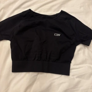 Svart kortärmad topp från ICANIWILL - Säljer en svart kortärmad topp från ICANIWILL. Toppen har en tight passform och är tillverkad i ett mjukt och stretchigt material. Perfekt för träning eller en avslappnad dag. Den har en diskret logga på bröstet och ryggen.