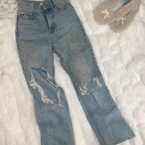 Blå jeans med slitningar från MNG - Snygga blå jeans från MNG med coola slitningar på benen. De är högmidjade och har en straight passform som ger en avslappnad look. Perfekta för en trendig stil!💓köpta för 799kr