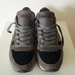 Philippe Model skor  - Snygga grå sneakers från Philippe Model med en stilren design. Skorna har en kombination av mocka och syntetmaterial med grå snörning. Perfekta för en casual look. Säljes då de inte passar längre.