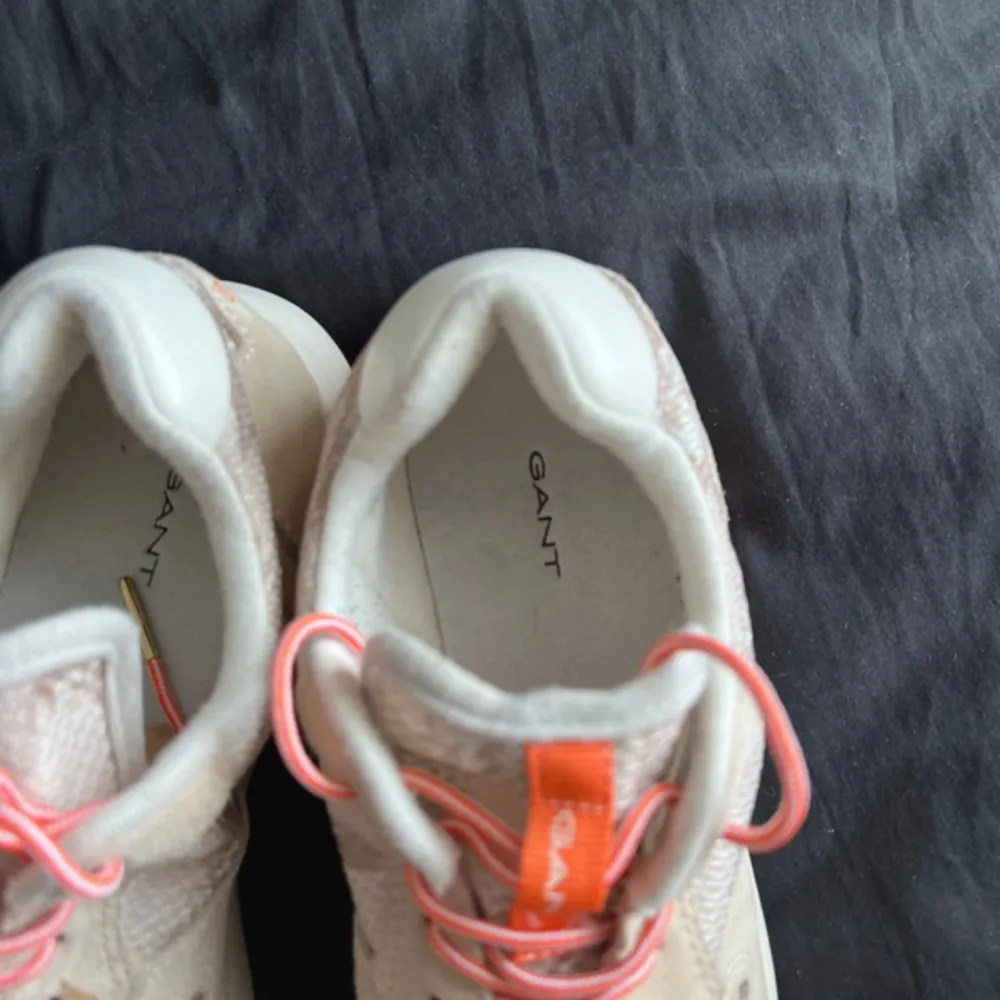 Snygga beige sneakers från GANT med orange detaljer och snörning. Skorna har en rund tå och en bekväm sula. Perfekta för en avslappnad stil.. Kengät.
