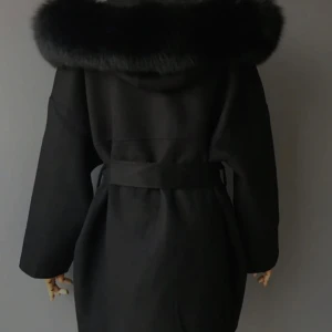 Svart kappa med pälskrage  - Elegant svart kappa med en lyxig pälskrage och bälte i midjan. Perfekt till våren  när du vill hålla stilen. Den har långa ärmar och en klassisk design som passar till många tillfällen. Inga skador alls, som ny! Använd ett fåtal gånger och skickar mer bilder till dig som vill.