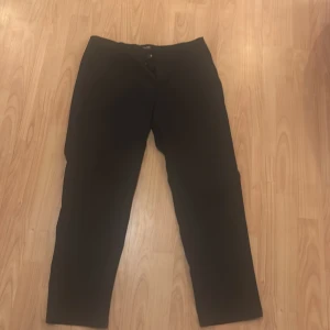 Svarta byxor från Jack & Jones - Snygga svarta byxor från Jack & Jones med en klassisk design. De har en normal passform och stängs med knappar. Perfekta för en stilren look.