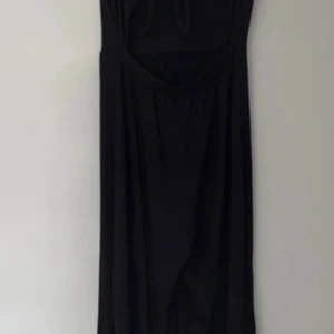 Svart jumpsuit byxdress från Stradivarius Medium - Snygg svart jumpsuit / byxdress från Stradivarius med smala axelband och knytning bak. Breda ben och mjuk och flowy. 