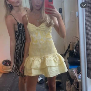 Gul kortklänning med volanger - SLUTSÅLD ZARA KLÄNNING Söt gul kortklänning med smala axelband och volanger. Klänningen har ett rutigt mönster och en knytning i ryggen som ger en fin detalj. Perfekt för sommarens varma dagar!