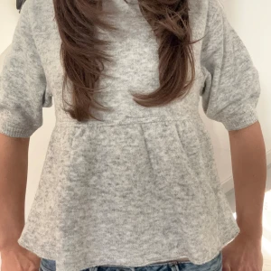 Grå stickad topp, helt ny aldrig använt. - Säljer en mysig grå stickad topp med trekvartsärmar och en lätt utsvängd nederdel. Perfekt för en avslappnad stil. Passar bra till jeans eller kjol. Pris kan diskuteras! Lappen sitter kvar och är helt ny. 