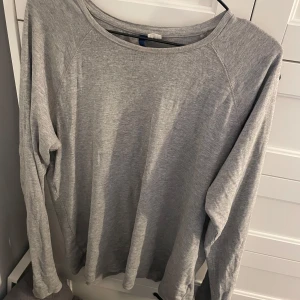 Grå långärmad tröja - Säljer en enkel och bekväm grå långärmad tröja. Perfekt för en avslappnad stil. Tröjan har en rund halsringning och är tillverkad i ett mjukt material.