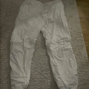 Vita linnebyxor från Gina Tricot - Säljer ett par vita byxor från Gina Tricot i storlek M. Byxorna har en avslappnad passform med resår i midjan och dragsko för justering. Perfekta för en bekväm och stilren look. Använda 1 gång