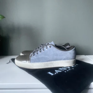 Ljusblåa sneakers från Lanvin - Snygga ljusblåa sneakers från Lanvin med en kombination av mocka och skinn. Skorna har en rund tå och snörning framtill. Perfekta för en stilren look. Nypris≈5000kr mitt pris 1700kr