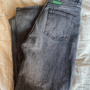 Grå baggy jeans från Monki - Säljer ett par grå baggy jeans från Monki. De är högmidjade och  W:26. Perfekta för en avslappnad stil. Helt nya med prislapp.