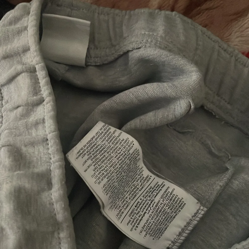 Säljer ett par grå mjukisbyxor från Nike med elastisk midja och snörning. Byxorna har ribbade muddar vid bensluten och en diskret Nike-logga på sidan. Perfekta för en avslappnad stil.. Farkut & Housut.