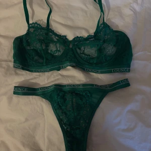 Grön spets-bh och trosa från Lounge - OANVÄND! Säljer ett set med grön spets-bh och matchande trosa från Lounge. Bh:n har justerbara axelband och en elegant spetsdesign💚
