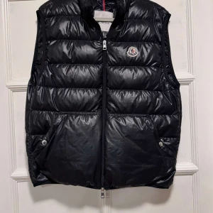 Moncler Aube down Väst  - Tjena! Säljer nu av en Moncler Aube Down väst till ett riktigt schysst pris i storleken 2! Västen är köpt från Moncler, ordinarie pris (kvitto finns). Västen har ett otroligt bra skick och har använts ett fåtal gånger. Hör av er vid fler frågor eller bilder. Ha det bäst!! ;)