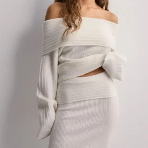 Vit ribbad offshoulder tröja - Säljer denna off shoulder tröjan från Nelly i storlek M.