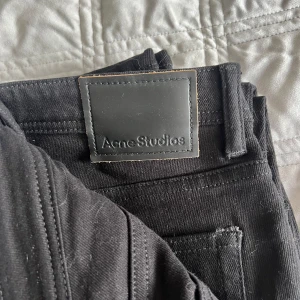 Svarta jeans från Acne Studios - Säljer ett par svarta jeans från Acne Studios. Klassisk femficksmodell med bälteshällor och snygga detaljer. Jeansen är i ett mjukt och slitstarkt bomullstyg med en stilren look som passar till det mesta.