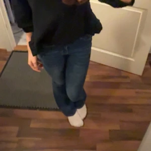Mörkblå bootcut jeans med hög midja - Snygga mörkblå jeans med bootcut-modell och hög midja. Jeansen har klassiska fickor fram och bak, dragkedja och knapp i midjan. Materialet är stretchigt jeans som sitter tajt upptill och släpper ut vid benslutet för en trendig siluett. De är storlek XS men de är väldigt stretchiga då jag vanligtvis använder storlek S