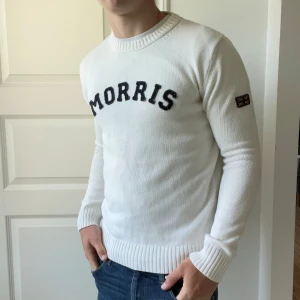 Vit Morris stickad sweatshirt  - Inga större defekter. Lite ludd fastnat på Morris bokstäverna men det händer alltid… kolla 3dje bilden för att se. Modellen är 180,75 kg. Kom med frågor!