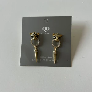 Guldörhängen - Super fina guldörhängen i rostfritt stål, de blir inte gröna och färgas av sig på huden. Helt nya och oanvända. Det är ett leopardhuvud