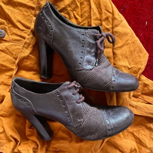 Bruna klackskor från Novita i skinn - bruna klackskor från Novita, tillverkade i Italien. med snörning, rund tå och en mix av skinn och textil. vintagevibbar, stl 39