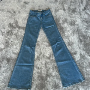 Blå bootcut jeans från ONLY XXS - Snygga blå bootcut jeans från ONLY i storlek XXS. Skulle säga att dem är lite mer vida än vanliga bootcut, men det är hur jag ser det! Längd 34 så passar mig som lite längre. Använda enstaka gånger så ser helt nya ut!!