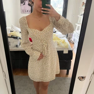 Blommig kortklänning med snörning - Superfin klänning från Adoore, aldrig använd.