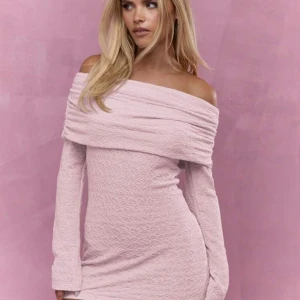 Ljusrosa offshoulder kortklänning - Supersöt ljusrosa kortklänning med offshoulder och långa ärmar. Klänningen har en snygg omlottkrage och är figurnära med struktur i tyget. Jag har aldrig använt den, perfekt nu till sommaren