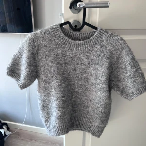 Grå stickad kortärmad tröja Gina Tricot - Supermjuk och fluffig grå stickad tröja från Gina Tricot. I storlek S🩶