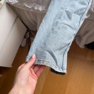 Ljusblå jeans från Kappahl, storlek 158 - Snygga ljusblå jeans från Kappahl med raka ben och klassisk femficksdesign. Jeansen har bakfickor med lock och knapp, samt dragkedja och knapp framtill. Perfekta för en chill och avslappnad stil.