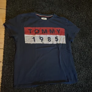 Marinblå t shirt från Tommy Hilfiger Jeans - En fin Tommy Jeans t-shirt som passar bra till nästan allting. Det är storlek L på den men den passar bättre på M den är använd och därför kostar den som den gör, inga hål på den.