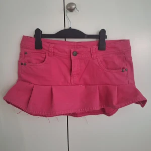 Rosa jeanskjol med volangkant - Supersöt rosa kort jeanskjol med volangkant nertill som jag sytt själv. Perfekt för dig som vill sticka ut med en färgglad och lekfull stil.